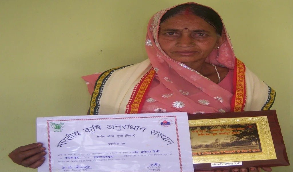 A participant holding a certificate and agricultural recognition plaque