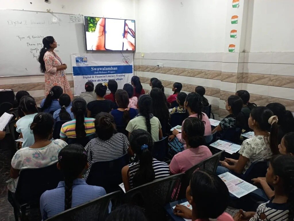 A facilitator leading a digital and financial literacy session for women
