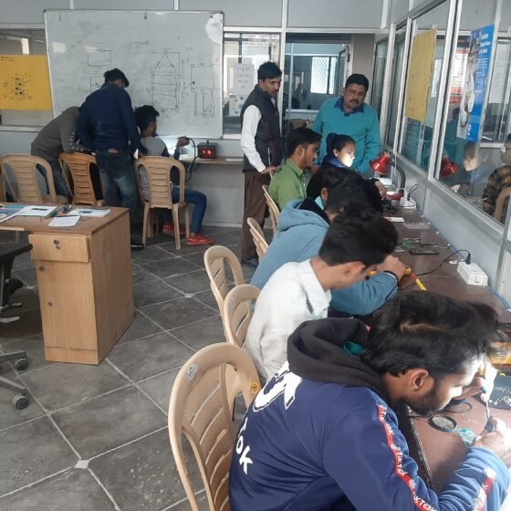 Young people practising technical repair work at a long workbench.