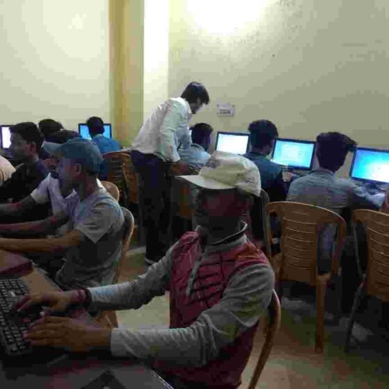 Young people practising on desktop computers during a training session.