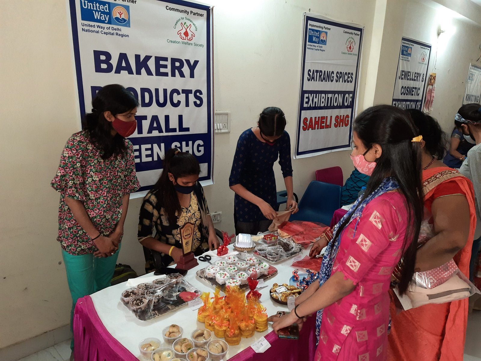 Women gathered around a table displaying packaged bakery and food products