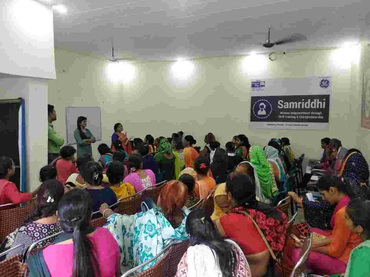 Women seated in a classroom while a facilitator leads a group discussion.